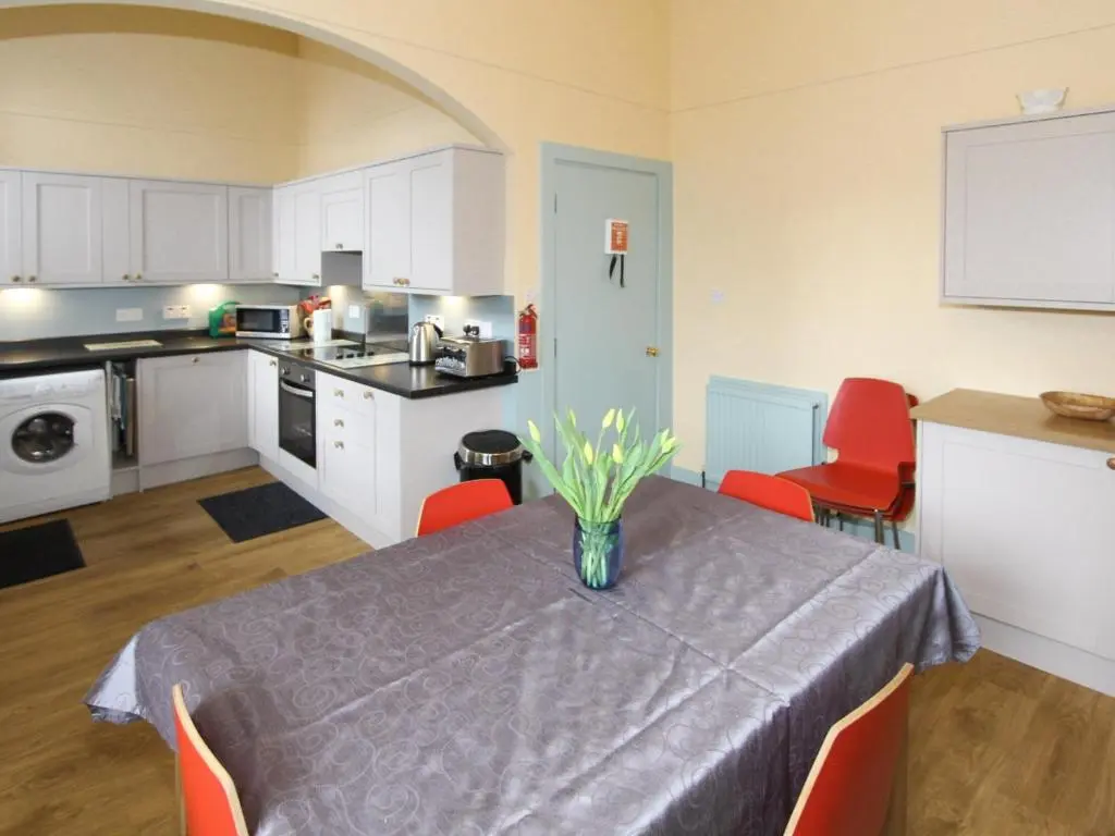 a kitchen with a table with a vase of flowers on it at The Townhouse in Inverness