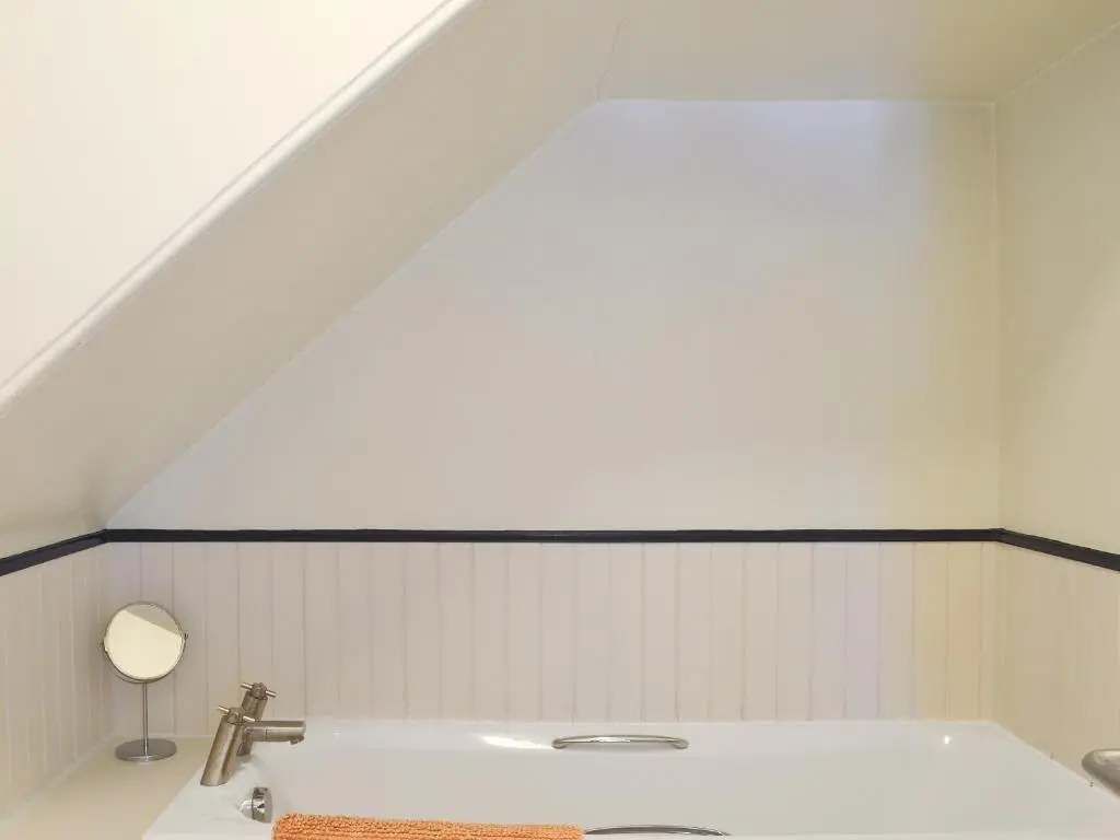 a bathroom with a white tub and a sink at Langside in Kingussie