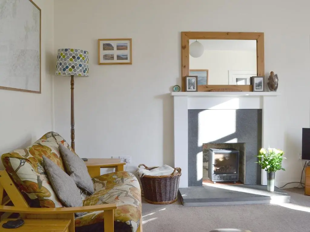 a living room with a couch and a fireplace at Langside in Kingussie