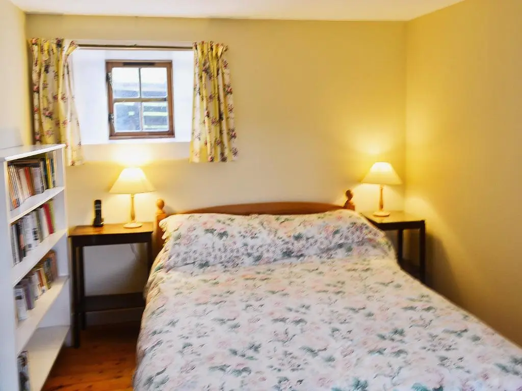 a bedroom with a bed and two lamps and a window at Rosscot in Ankerville