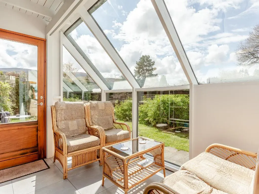 a conservatory with two chairs and a table at The Coyles Cottage - Sbh in Ballater