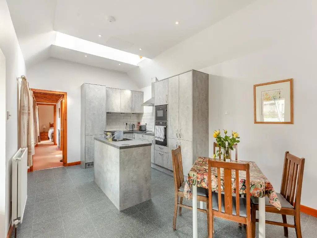 a kitchen and dining room with a table and chairs at The Coyles Cottage - Sbh in Ballater