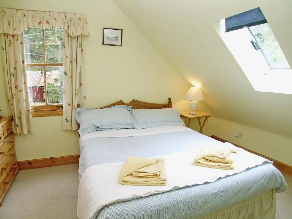a bedroom with a bed with towels on it at Mar House in Braemar