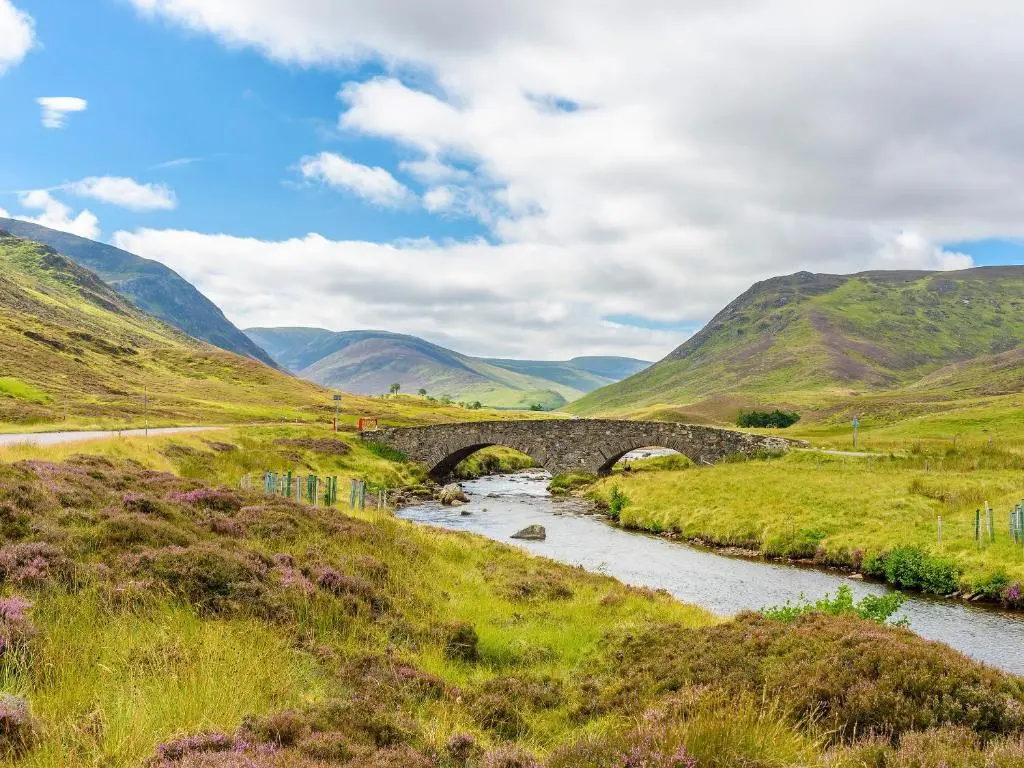 a stone bridge over a river in the hills at Mar House in Braemar