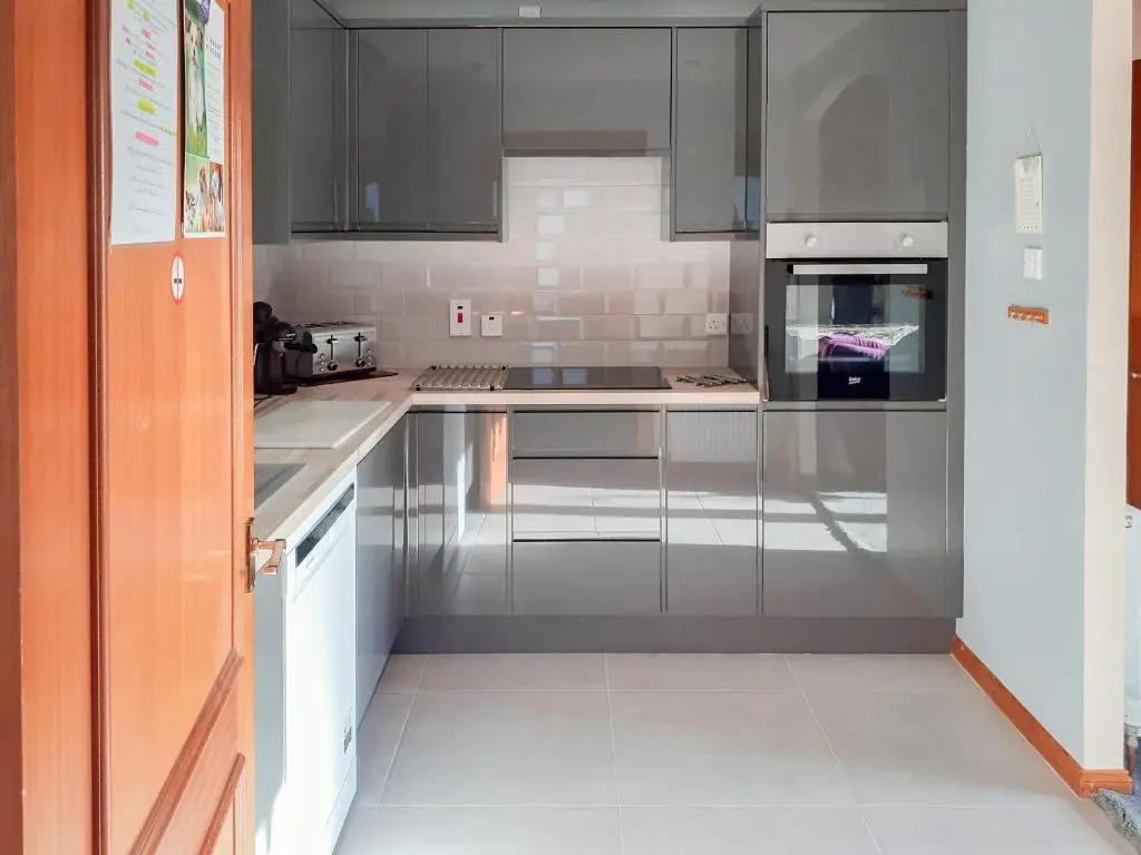 a kitchen with stainless steel appliances and gray cabinets at Park Lodge in Strachan