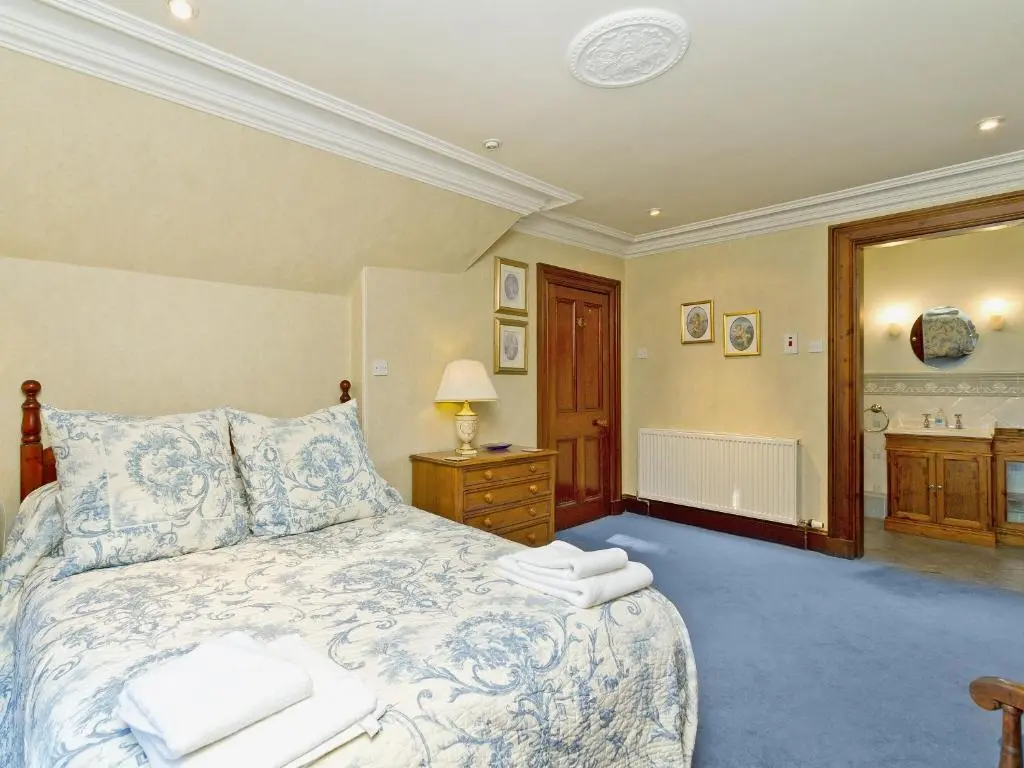 a bedroom with a bed with two towels on it at Dess Lodge in Kincardine O\u02bcNeil