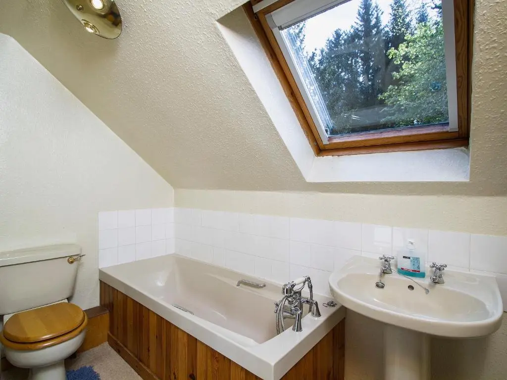 a bathroom with a sink and a toilet and a window at Tinkerbell in Balnaboth