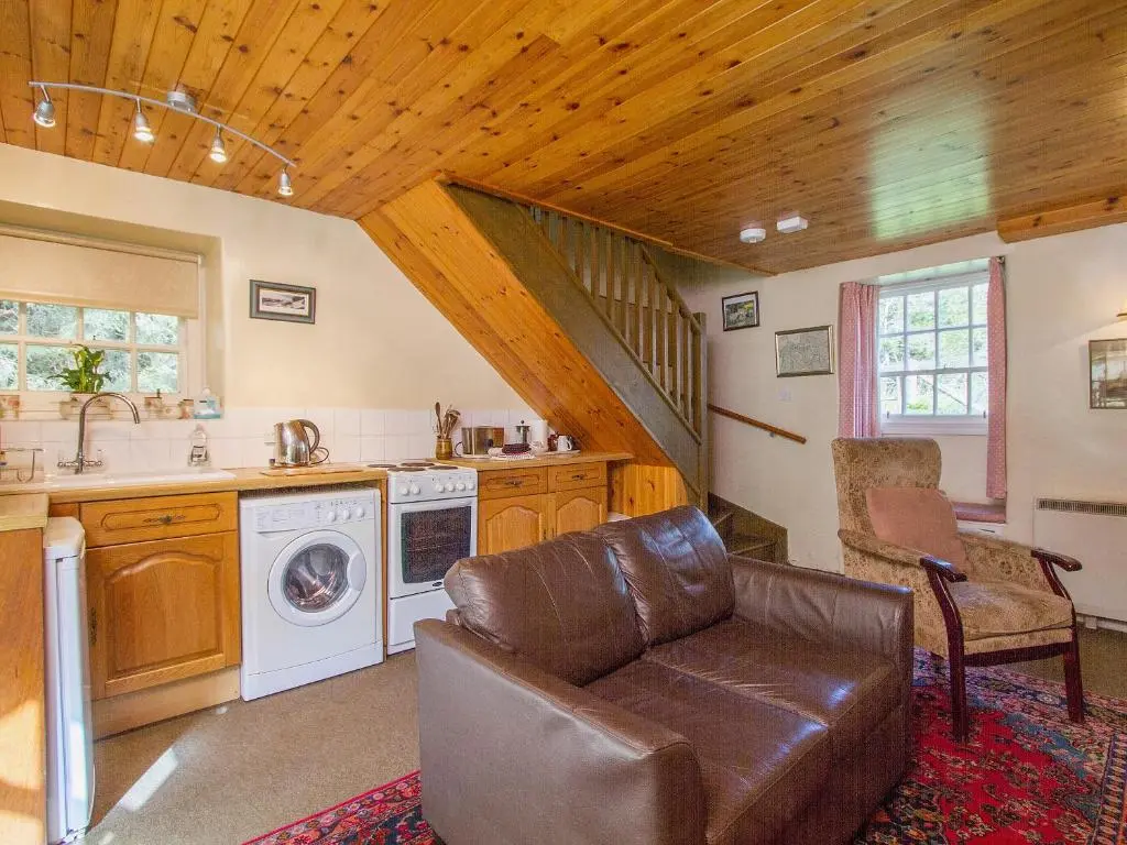 a living room with a couch and a sink and a kitchen at The Old Laundry in Balnaboth