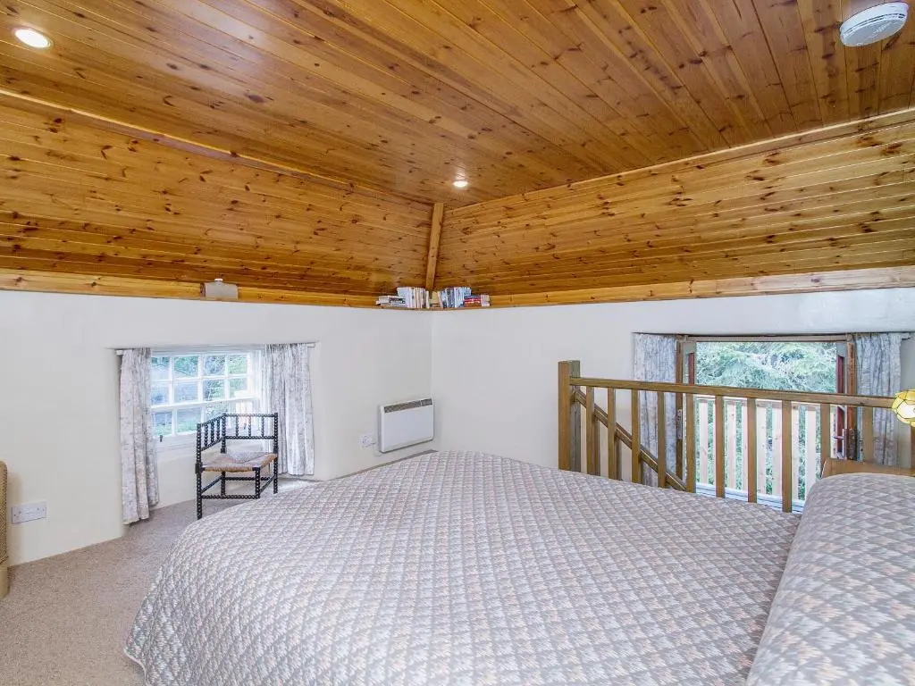 a bedroom with a bed and a wooden ceiling at The Old Laundry in Balnaboth