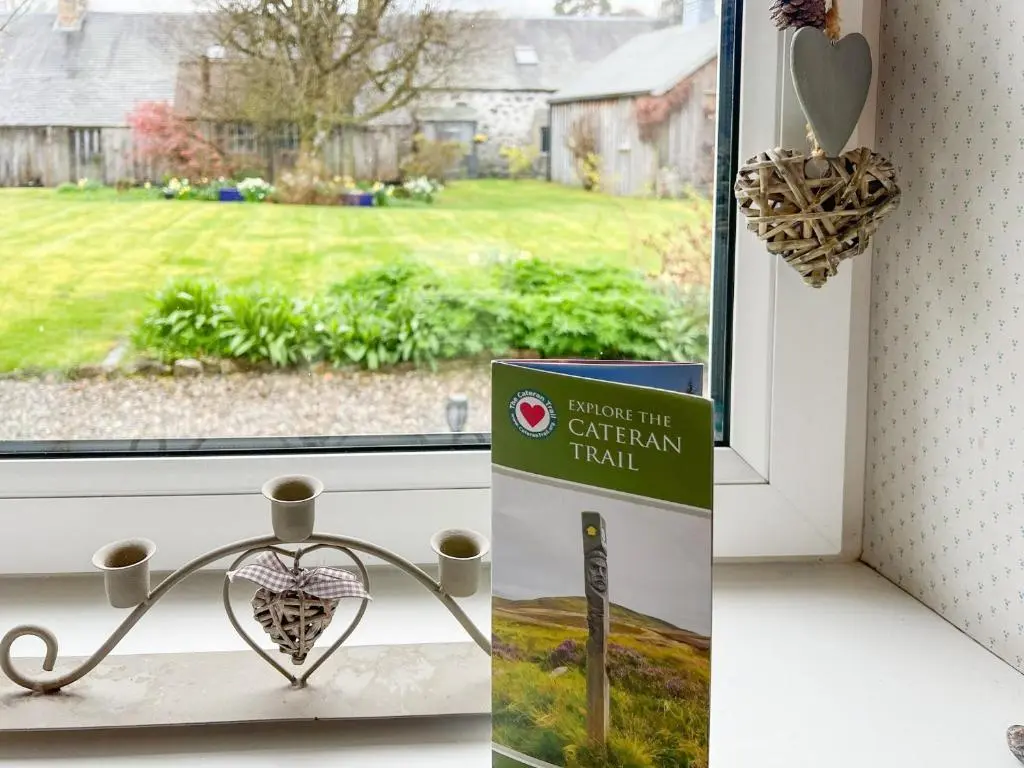 a sign sitting on a window sill next to a window with a garden field at Sunnyside in Kirkmichael