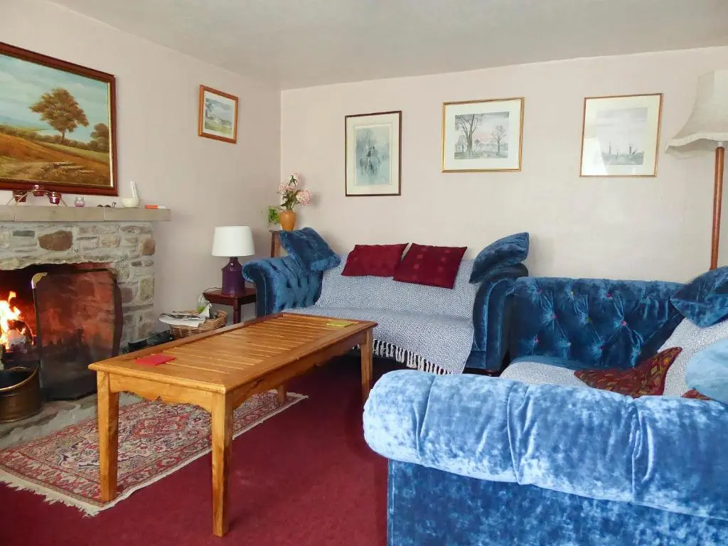 a living room with a couch and a fireplace at The White House in Pitlochry