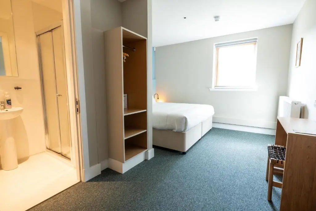 a hotel room with a bed and a bathroom at An Spiris Accommodation at Dundreggan Rewilding Centre in Dundreggan