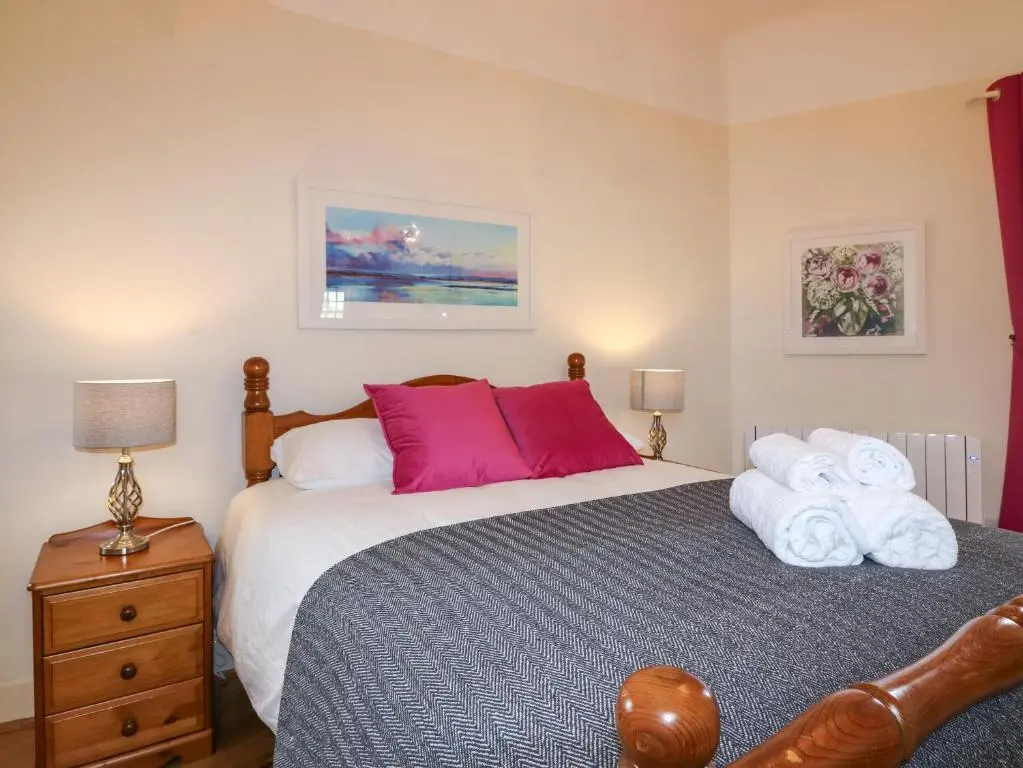 a bedroom with a bed with towels on it at Holly Leaf Cottage - Drum Castle Estate in Banchory