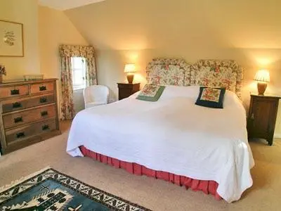 a bedroom with a large white bed and a dresser at Dhuallow in Aberarder
