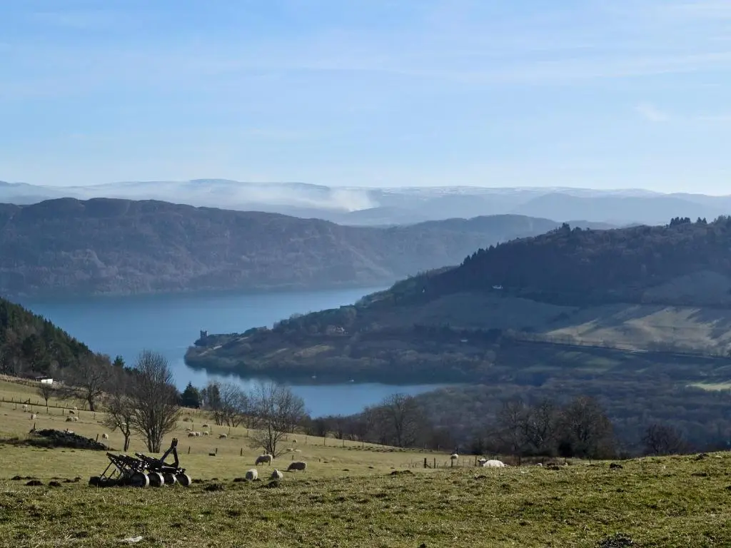 a person standing on a hill with a view of a lake at Dhuallow in Aberarder