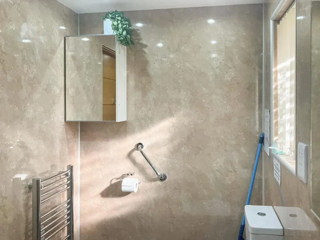 a bathroom with a toilet paper dispenser on the wall at Thistle Dubh in Drumnadrochit