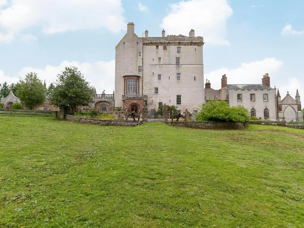 an old castle on a hill with a grass field at Symbister Suite in Turriff