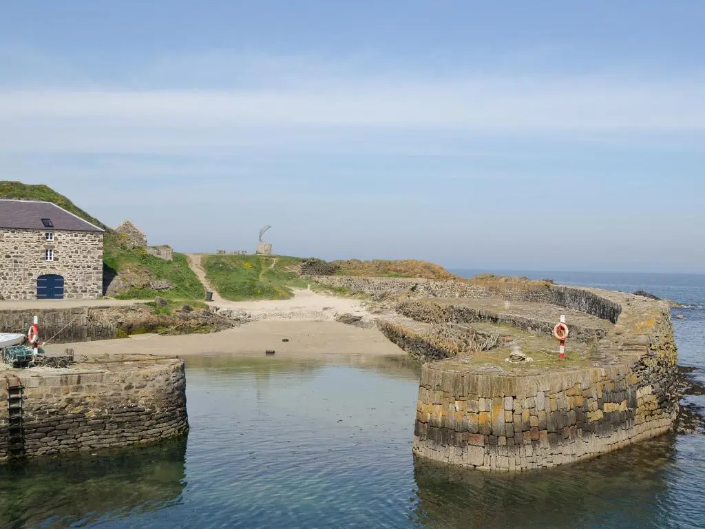 a group of pillars in the water next to a beach at Scobach Lodge in Turriff