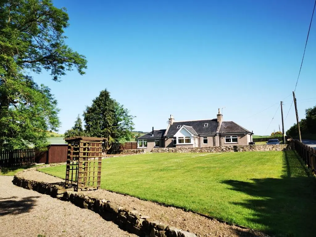 a house with a large yard in front of it at Private peacefull pet friendly converted country cottage in Keig