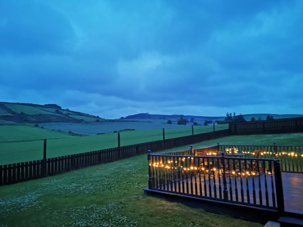 a fence with lights in a field at night at Private peacefull pet friendly converted country cottage in Keig