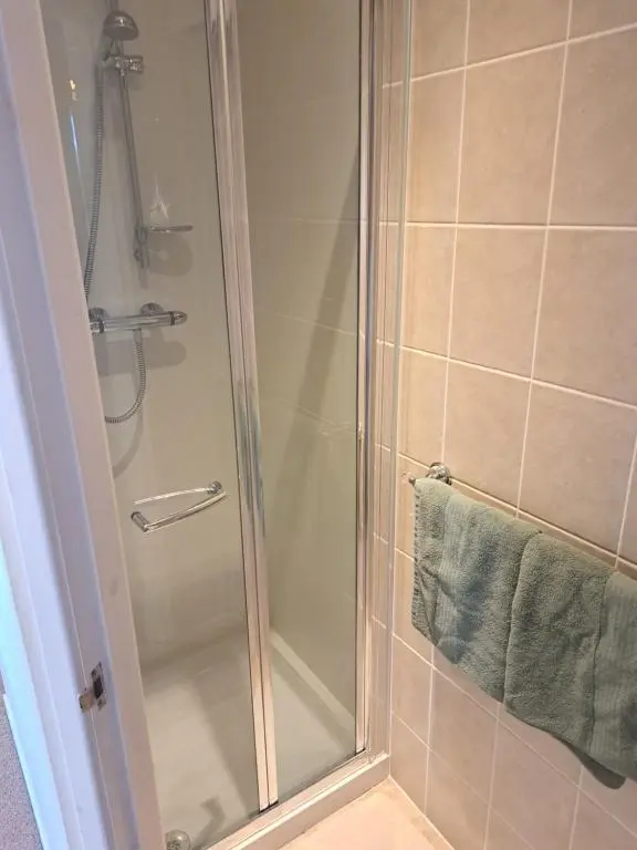 a shower with a glass door in a bathroom at No 27 in Inverness