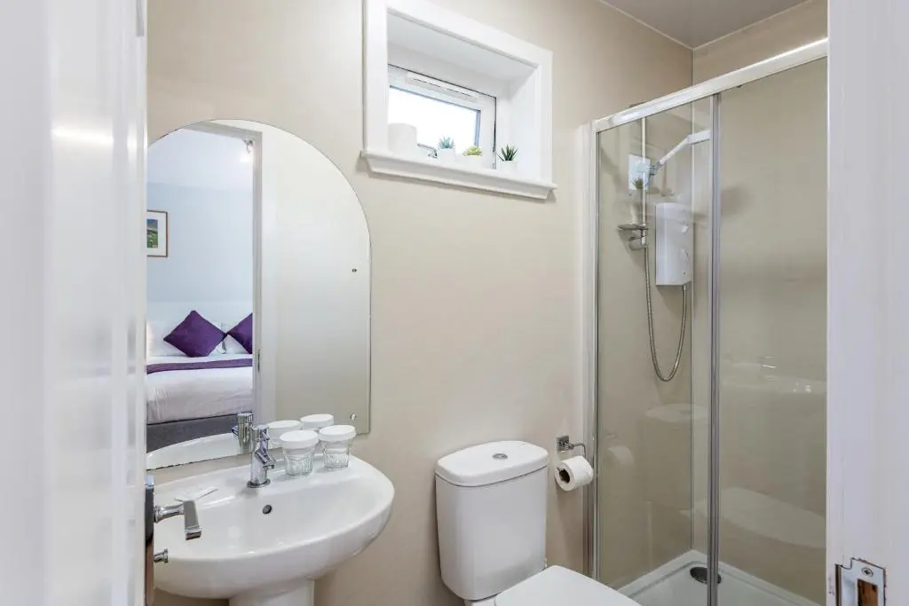 a bathroom with a toilet and a sink and a shower at High Range Self-Catering Chalets in Aviemore