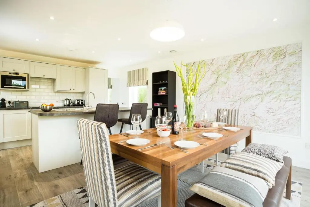 a kitchen and dining room with a wooden table and chairs at Tomdhu Lodge - Seasgair Lodges in Boat of Garten
