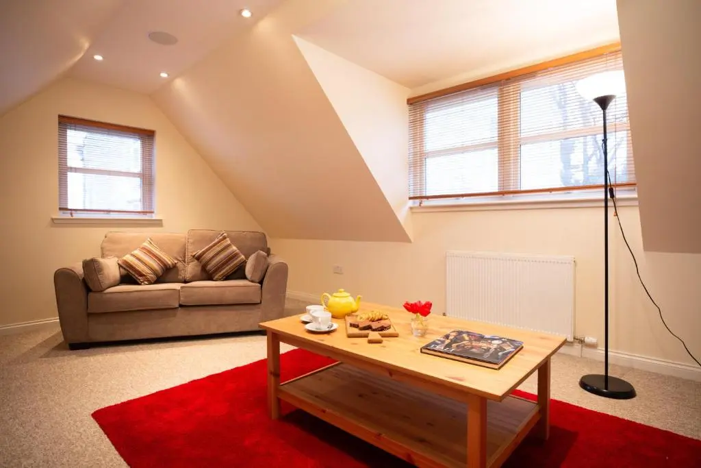 a living room with a couch and a coffee table at Craigard Lodge - Seasgair Lodges in Boat of Garten