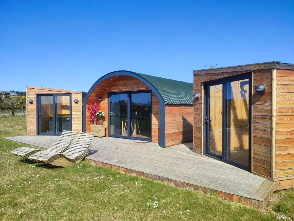 a house with a deck and chairs on a field at Ben Aigan in Keith