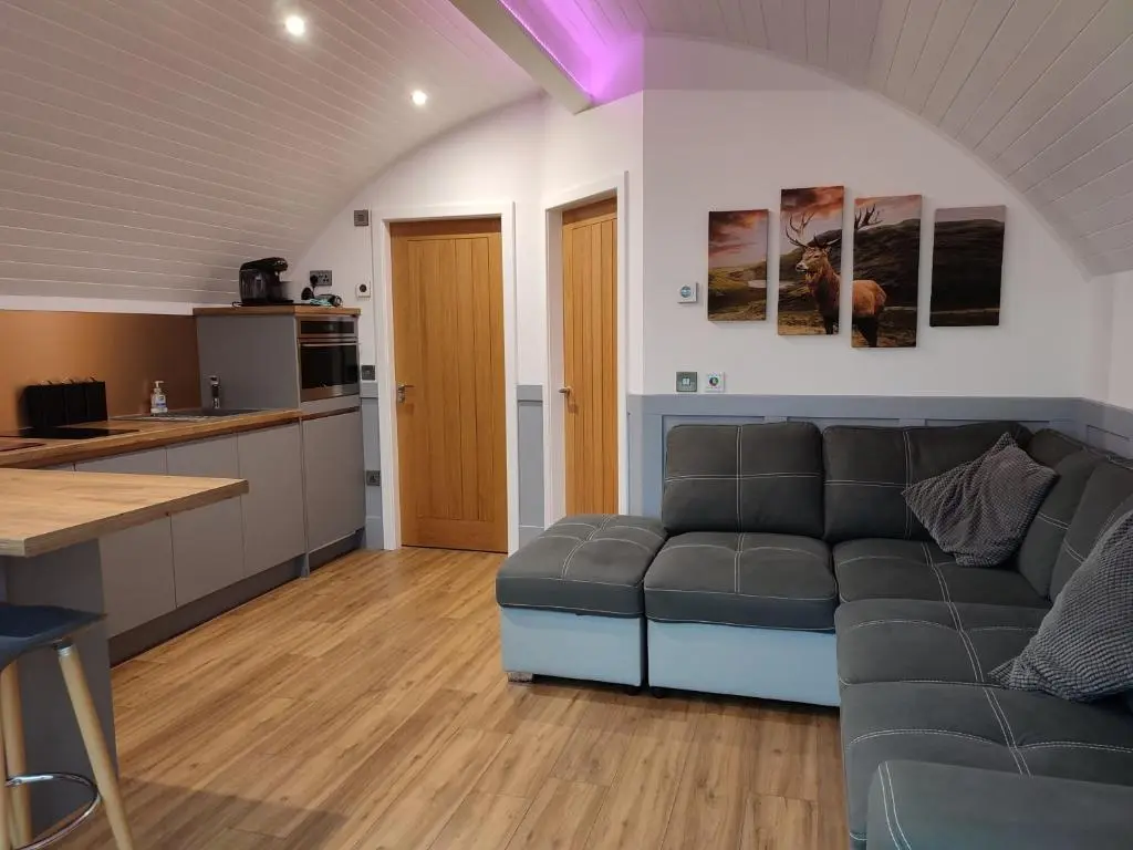 a living room with a couch and a kitchen at Meikle Balloch in Keith