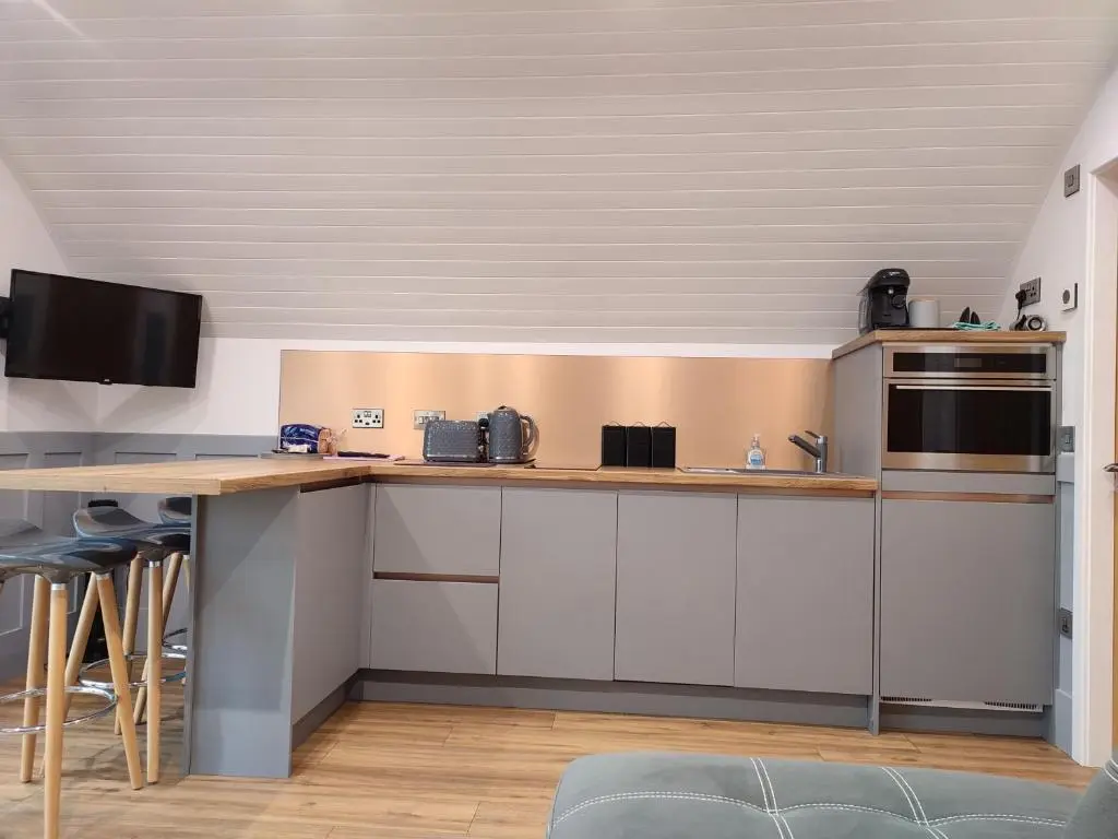 a kitchen with white cabinets and a counter top at Meikle Balloch in Keith