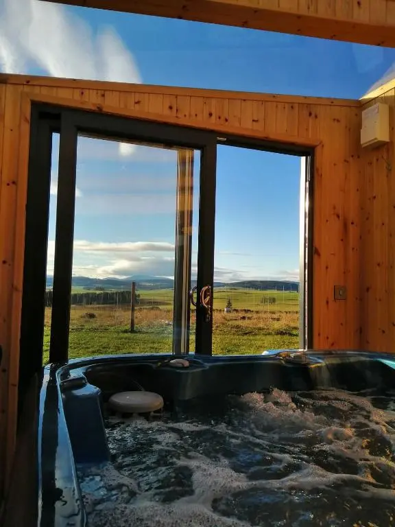 a jacuzzi tub in a room with windows at Ben Rinnes in Keith