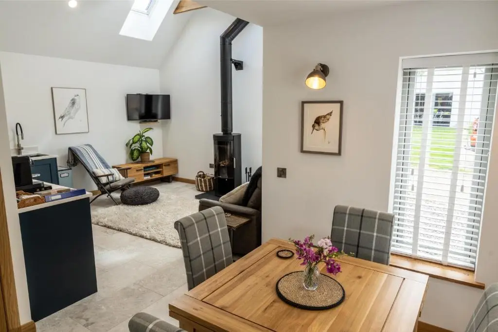 a living room with a wooden table and chairs at Lily Cottage - 1 bedroom in Forres