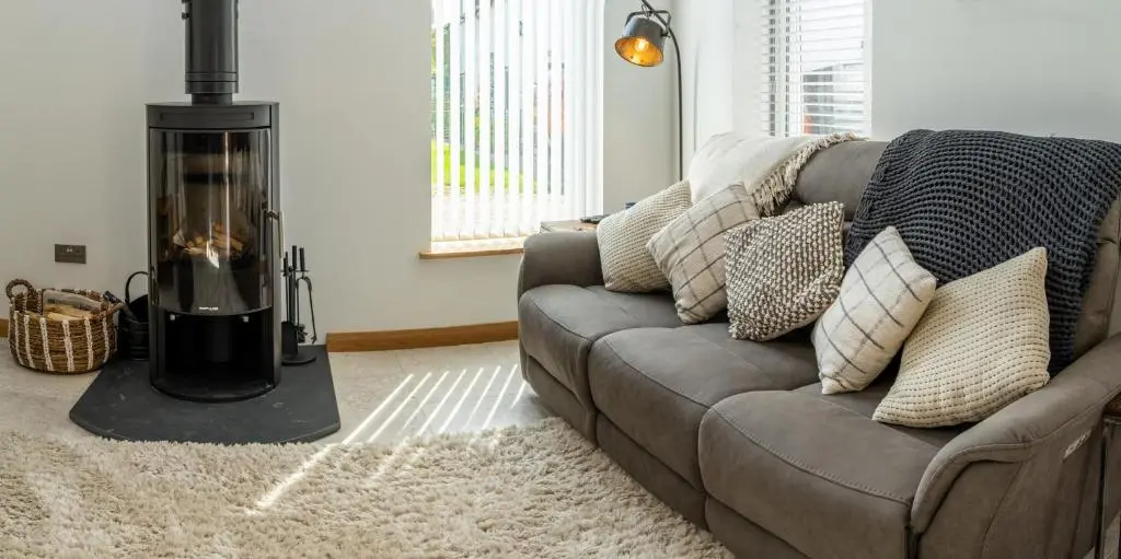 a living room with a couch with a fireplace at Lily Cottage - 1 bedroom in Forres