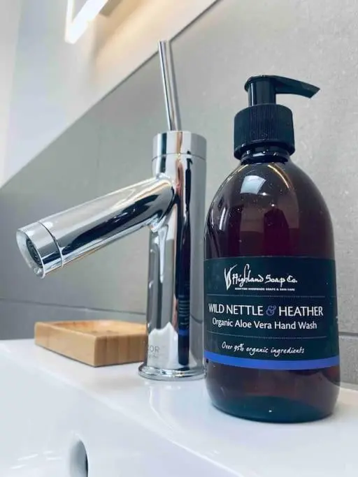 a bottle of moisturizing hand soap next to a bathroom sink at Lily Cottage - 1 bedroom in Forres
