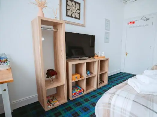 a living room with a tv and a bed at Nairn View Guest House in Nairn