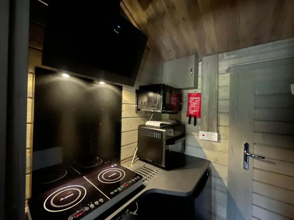 a small kitchen with a stove and a microwave at Daisy Cabin in Kincardine O\u02bcNeil