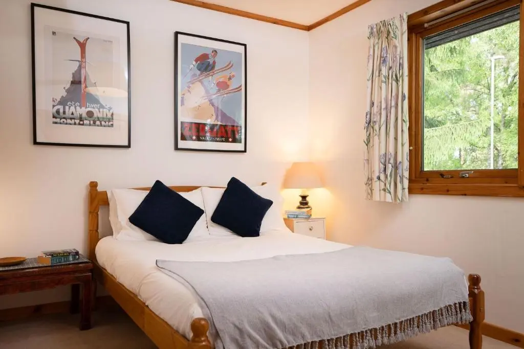 a bedroom with a bed and a window at Langrick in Nethy Bridge