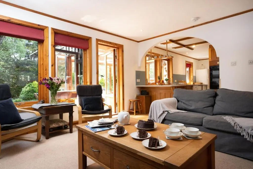 a living room with a couch and a table at Langrick in Nethy Bridge