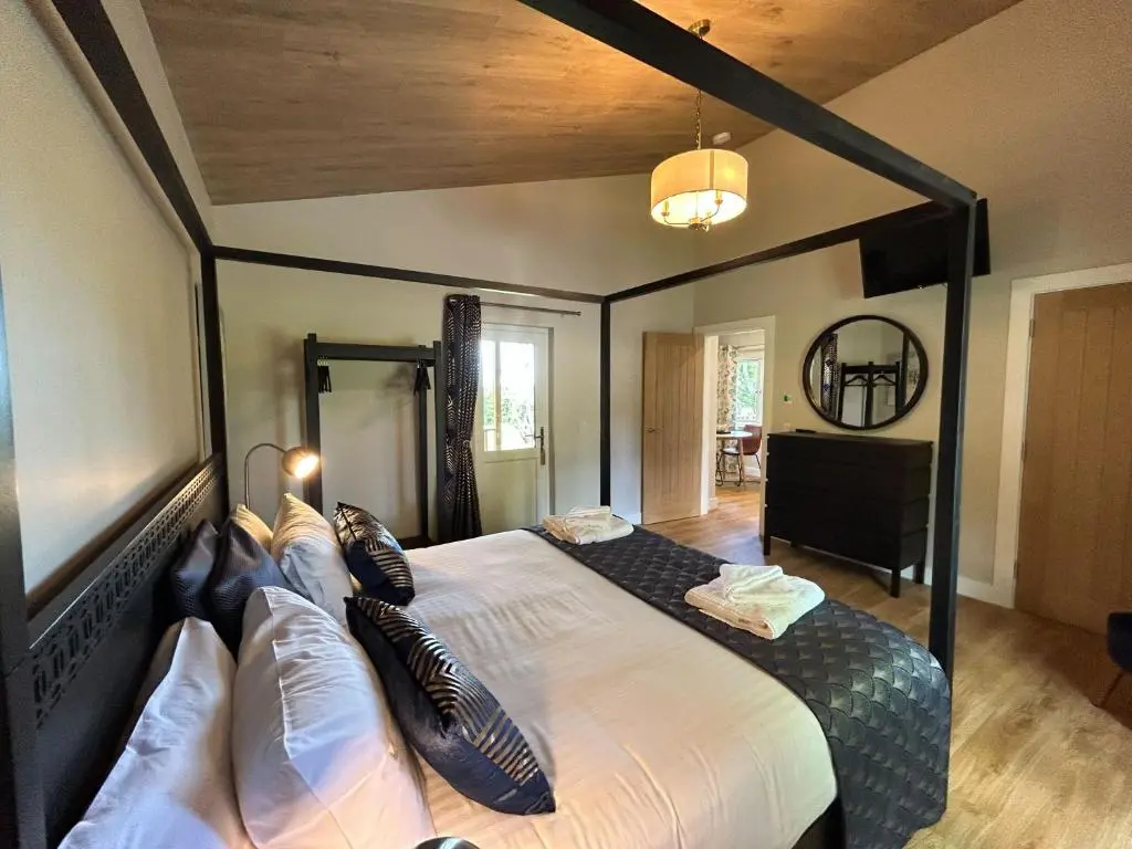 a bedroom with a large bed in a room at Breckland Lodge 3 with Hot Tub in Belladrum