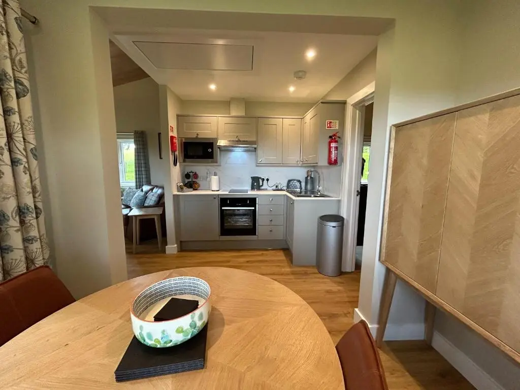 a kitchen with a table with a bowl on top of it at Breckland Lodge 3 with Hot Tub in Belladrum