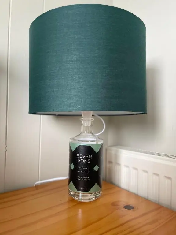 a lamp sitting on a table with a green lamp shade at Impala Guest House in Wick