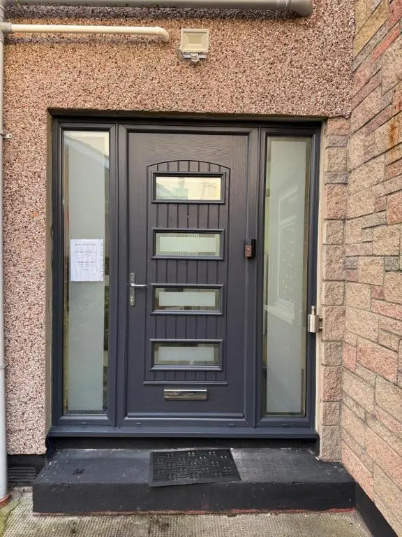 a purple door on the side of a building at Impala Guest House in Wick