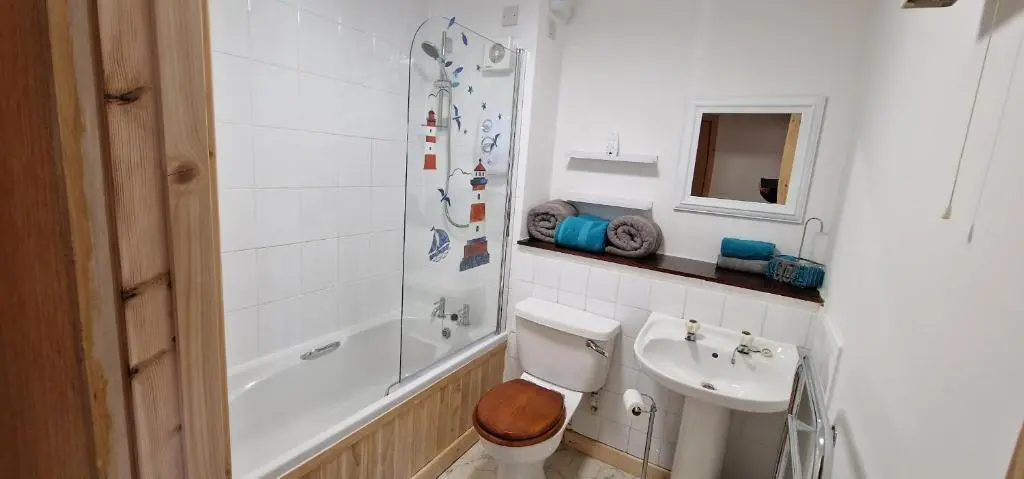a bathroom with a toilet and a sink and a shower at Colin Young Place in Nairn