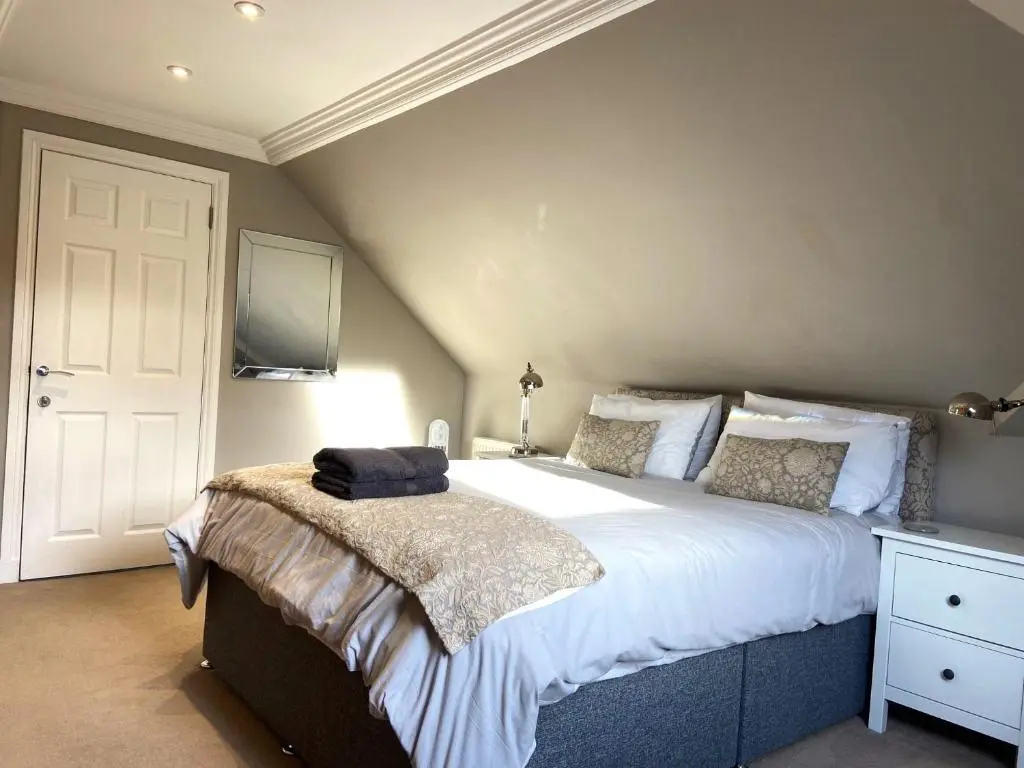 a bedroom with a large bed with a television on the wall at 26 Green Drive Inverness in Inshes