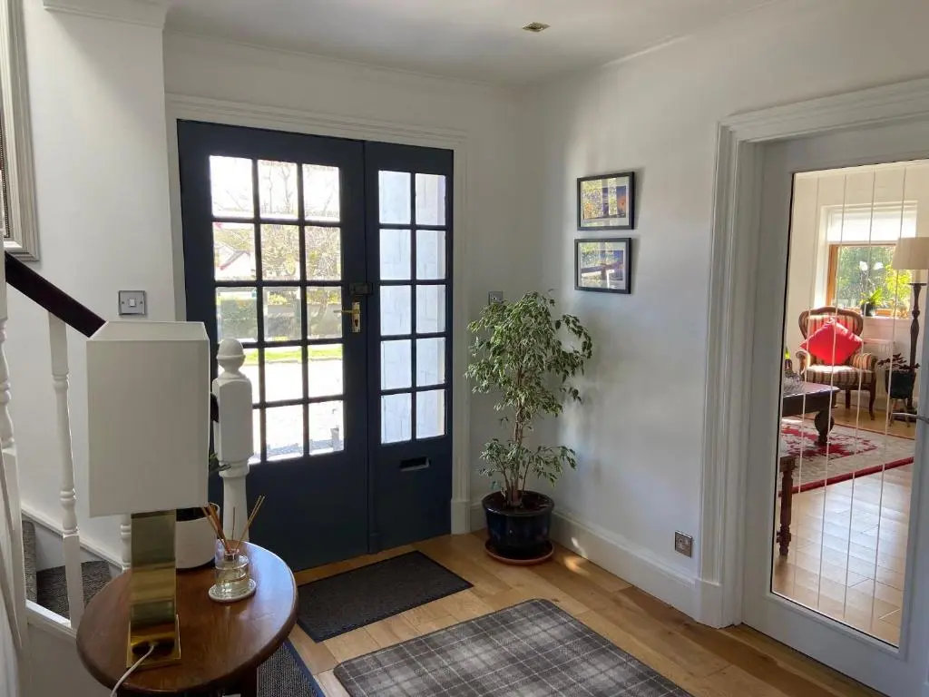 a living room with a door and a table and a plant at 26 Green Drive Inverness in Inshes