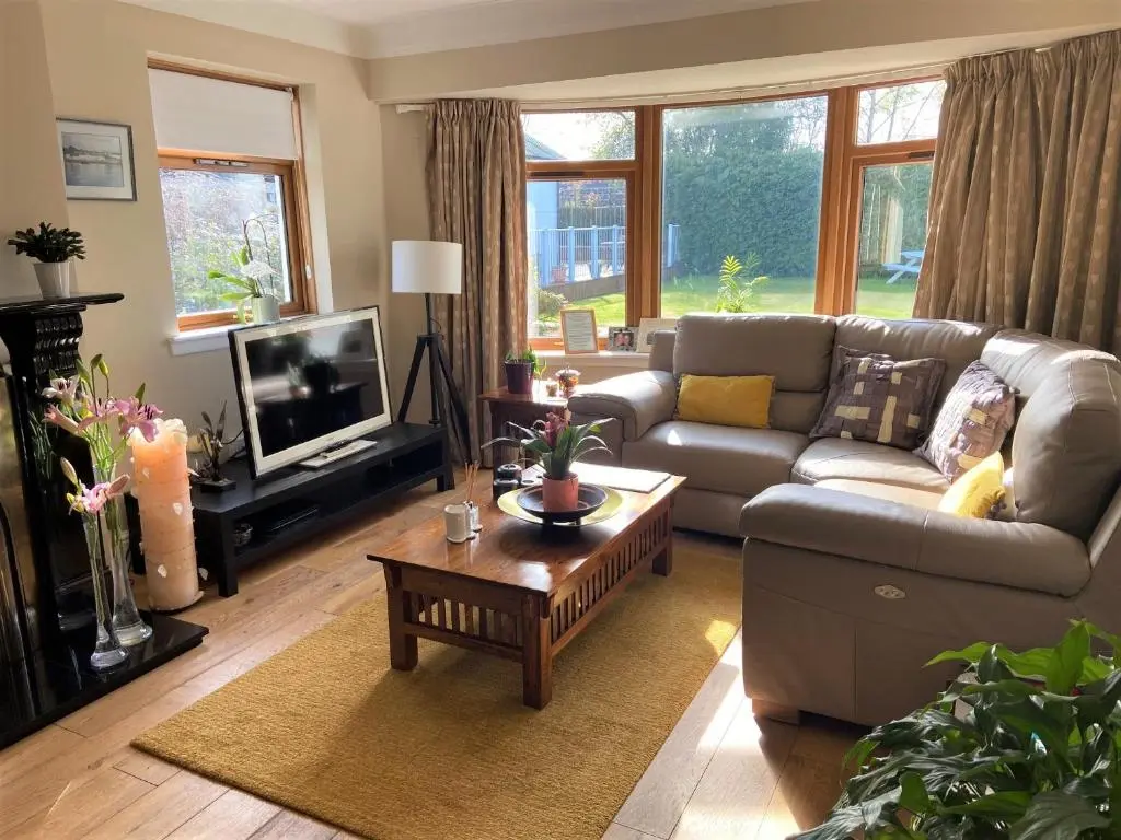 a living room with a couch and a coffee table at 26 Green Drive Inverness in Inshes