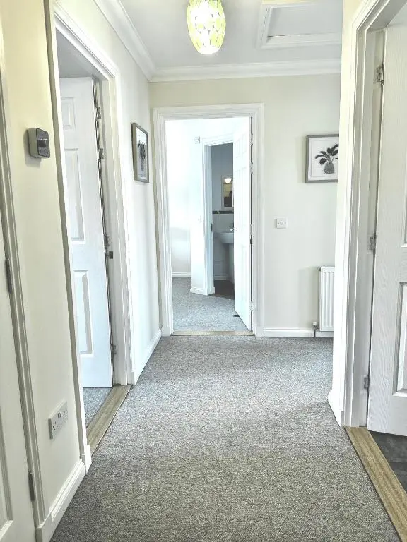 a hallway with white walls and a hallway leading to a bathroom at Riverview Apartment 2 bed, 2 bath, Free Parking / WiFi in Inverness