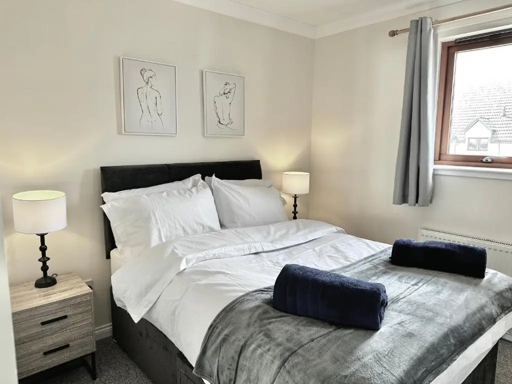 a bedroom with a large bed and a window at Riverview Apartment 2 bed, 2 bath, Free Parking / WiFi in Inverness