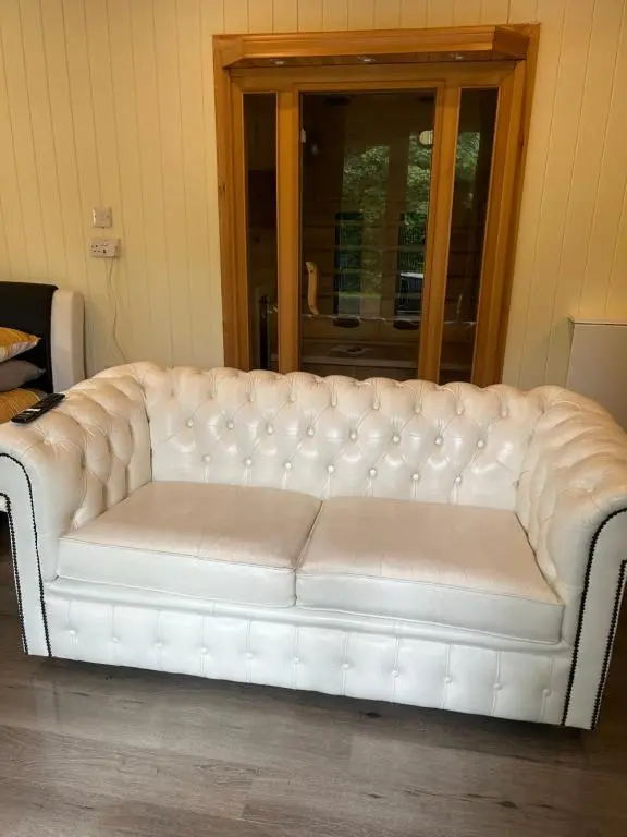 a white leather couch sitting in a room at 1Lochness glam lodges in Inverness
